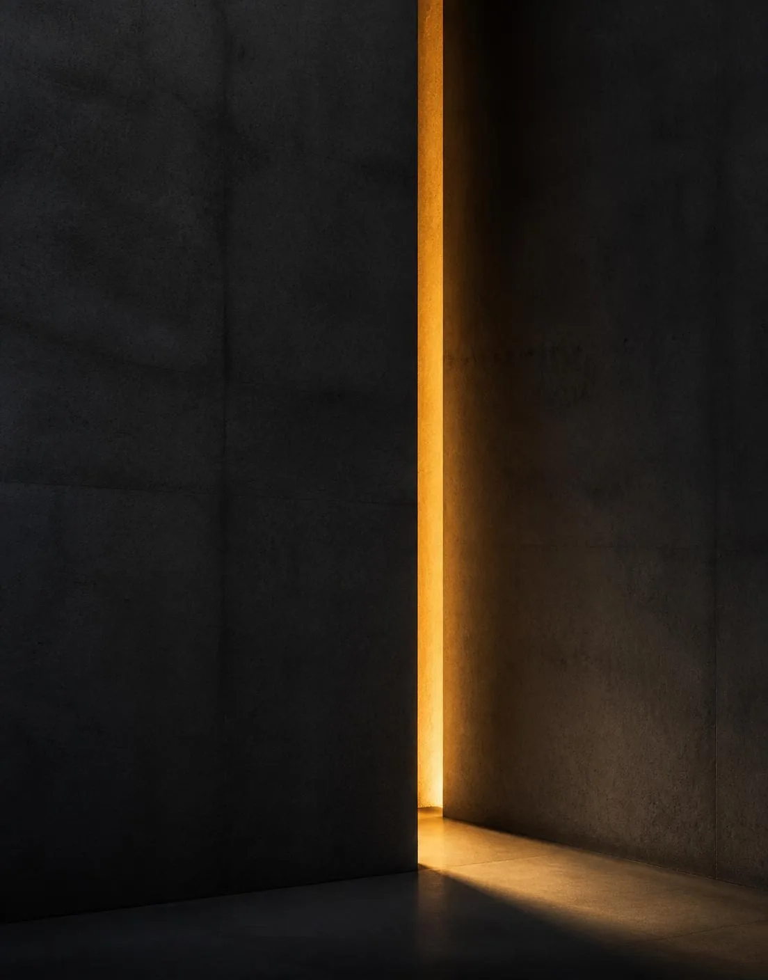 Estudo arquitetônico abstrato: parede de concreto grafite com fenda vertical de luz dourada